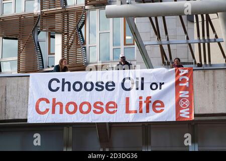 Edinburgh, Scotland, UK. 8 October 2020. Extinction Rebellion stage protest on roof of Scottish Parliament building at Holyrood in Edinburgh.  The group, Extinction Rebellion Scotland have hung a banner reading 'Choose Oil or Choose Life'  in a protest against fossil fuels. Iain Masterton/Alamy Live News Stock Photo