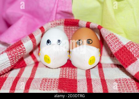 virus pandemic concept Funny two eggs in different colors together. Photo for your design. Eggs on a white-red checkered towel Stock Photo