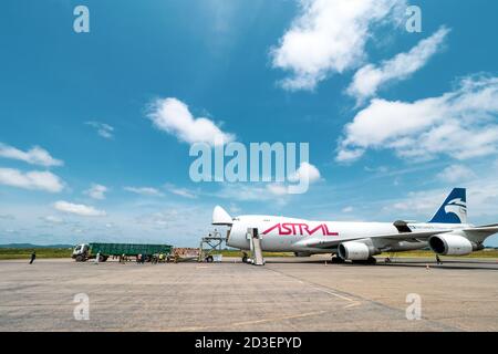 Scenic view of a Boeing 747 Jumbo Jet freighter aircraft with a wide open nose cargo door being offloaded by a high-loader at a cargo ramp Stock Photo