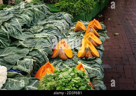 Turkish farmer market. Heap of fresh organic vegetables on the counter greens, spinach, sliced pumpkins Stock Photo