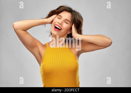 happy laughing young woman in mustard yellow top Stock Photo