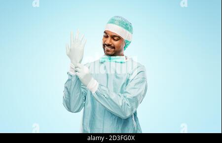 indian male doctor or surgeon putting glove on Stock Photo
