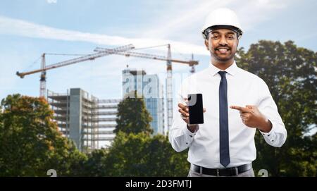 architect showing smartphone at construction site Stock Photo