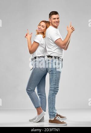 couple in white t-shirts shirts making gun gesture Stock Photo