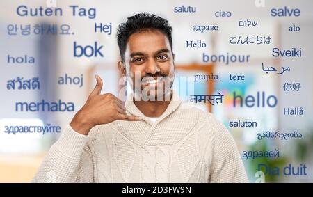 indian man in sweater making phone call gesture Stock Photo