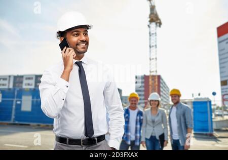 architect calls on smartphone at construction site Stock Photo
