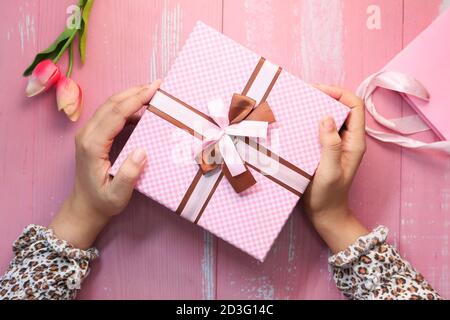 women hand holding pink color gift box, top view  Stock Photo