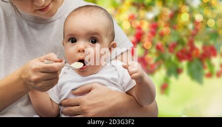 close up of mother with spoon feeding little baby Stock Photo