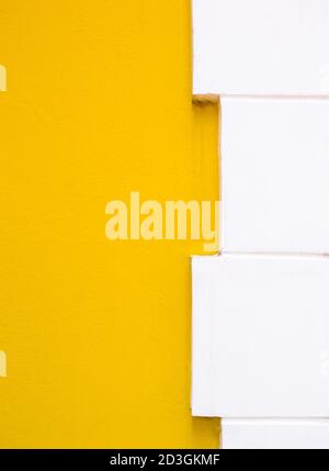 Yellow painted wall with the white brick border of the church wall in Thai temple. Stock Photo