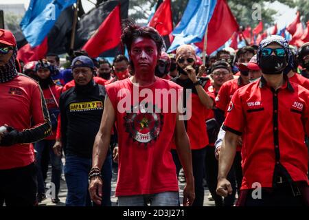 Cileunyi, Indonesia. 08th Oct, 2020. Protesters stand in lines to form barricades against police during the protest in Rancaekek.Labour Unions and Student Unions took to the streets, blocking the Bandung-Garut-Tasikmalaya national road to the Cileunyi Toll Gate. They protest against the new job creation law that was passed by Parliament on Monday. Credit: SOPA Images Limited/Alamy Live News Stock Photo