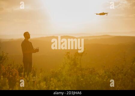 Drone operator man piloting a Drone In A Rural Setting Stock Photo