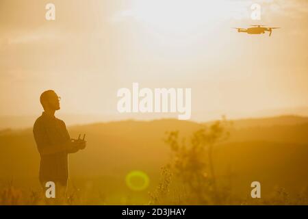 Drone operator man piloting a Drone In A Rural Setting Stock Photo