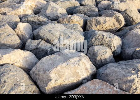 Big rough stones and rocks texture (background), forming a pier in Dubai. Stock Photo