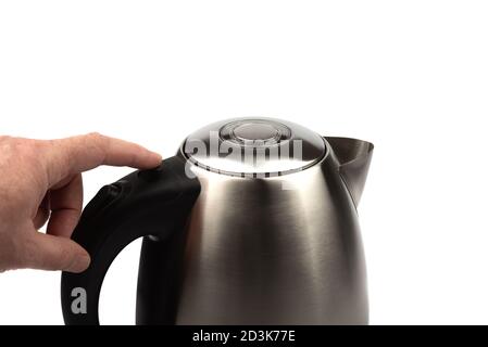A man tries to press the button to open the teapot lid. Electric kettle on a white background. Stock Photo