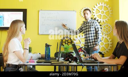 Group of students working together in classroom with laptops Stock Photo