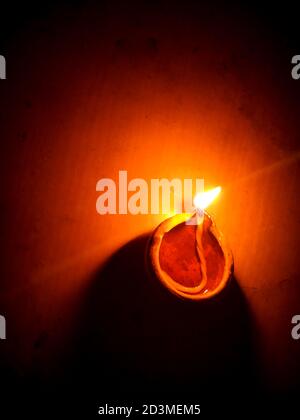 Colorful clay diya lamps lit during diwali celebration.Close up of heap of Indian clay oil lanterns or diyas for Diwali festival celebration at local . Stock Photo