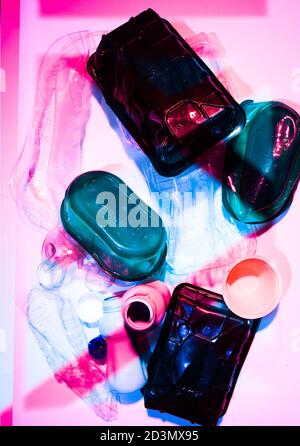 Plastic nightmare is a conceptual image that depict th influence of plastic in our lives, a group of plastic bottles and container over a colored back Stock Photo