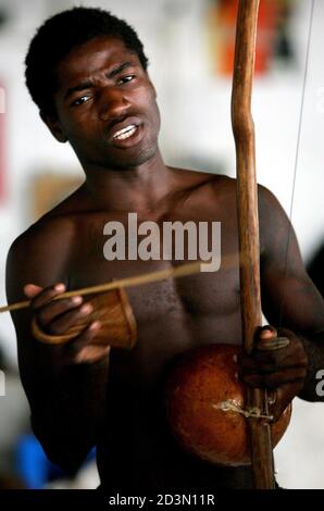 -PHOTO TAKEN 25APR05- A young Angolan plays the berimbau during a Capoeira session in Luanda, Angola April 25, 2005. The berimbau is central to Capoeira play, it's hypnotic beat serving to set the pace and rythm,  and to calm players down when the game becomes heated. Music plays an important role in Capoeira, a blend of dance, music, acrobatics and martial art, [which links two of Portugal's most important former colonies, Angola and Brazil.] It has its roots in the slave era when fearful colonial authorities prohibited slaves from engaging in martial arts, but allowed them to dance to the be