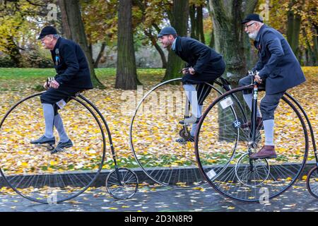 Three cyclists on Penny Farthing bicycle cycle race Stock Photo