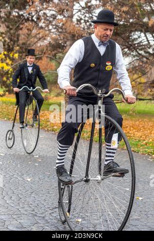 Four men on Penny Farthing bicycle Men cycling Stock Photo