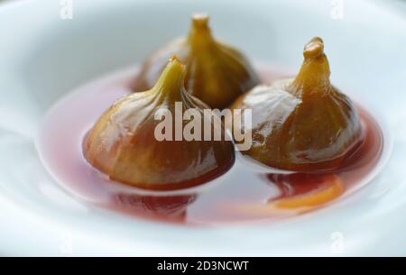 Closeup shot of three figs in syrup dessert Stock Photo