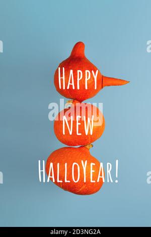 A snowman with a carrot nose of three orange pumpkins on a blue background. Halloween concept. Stock Photo