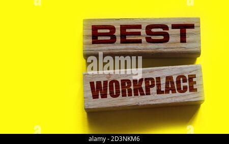 Hand of a businessman holding wooden blocks. Conceptual image. Text BEST WORKPLACE. concept business succeed. Stock Photo