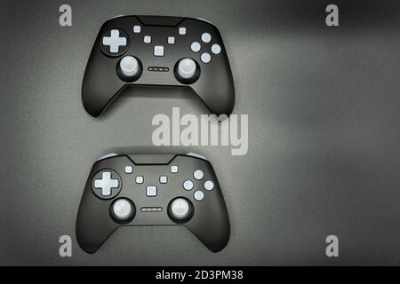 Two black game joysticks with white buttons isolated on gray background Stock Photo
