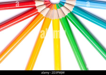circle or semicircle of colored sharp pencils spouts in the center on a white isolated background Stock Photo