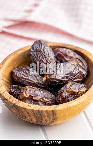 Dried dates fruit in wooden bowl. Stock Photo