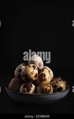still life, quail eggs on a plate on a dark background, close-up Stock Photo