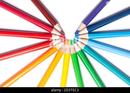 circle or semicircle of colored sharp pencils spouts in the center on a white isolated background Stock Photo