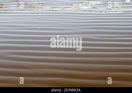 Periodicity - Mild Pacific surf carves a regular pattern in the beach sand. Pismo Beach, California, USA. Stock Photo