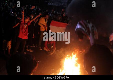 Palembang, Indonesia. 08th Oct, 2020. Demonstrators burn tires as a form of protest against the passing of the Omnibus Law by the Indonesian People's Representative Council in front of the South Sumatra Dewan Perwakilan Rakyat Daerah building Thursday, October 8, 2020. (Photo by Adam Rachman/Pacific Press) Credit: Pacific Press Media Production Corp./Alamy Live News Stock Photo