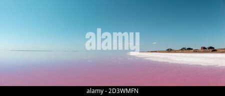 Pink salt lake coast with white salt, pink water and reflection of blue sky. Syvash or Sivash, the Putrid Sea or Rotten Sea, Ukraine Stock Photo