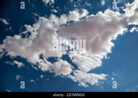 High epic clouds with pink and purple coloration on deep blue sky. Heaven cloudscape air view Stock Photo