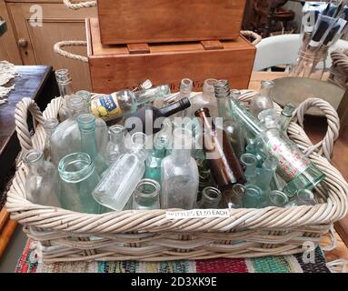 Old Glass bottles in a basket, Bromsgrove Worcester, Worcestershire.  England, UK,United Kingdom, 07/09/2020 Old Glass bottles lay in a wicker basket. Stock Photo