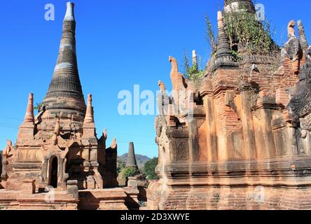 Old stone pagodas with green plants growing out of them at In Dien located on the southwestern side of Inle Lake, Myanmar