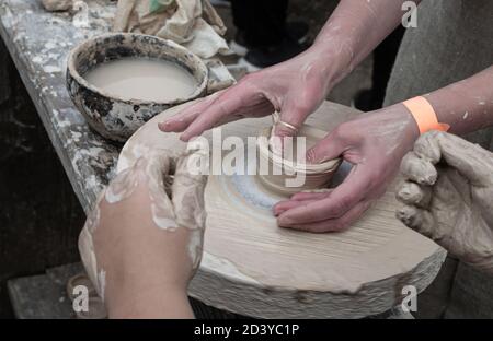 Clay modeling training on a potters wheel in the open air. Art, creativity. Modeling clay, cultural traditions, hobby Stock Photo