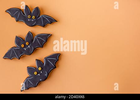 Halloween pattern for postcard. Cheerful black bats are isolated on an orange background. Congratulations on the holiday. Children's food, Copy space Stock Photo