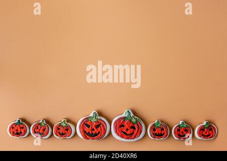 Halloween pattern for postcard. Small and large pumpkins lie isolated on an orange background. Congratulations on the holiday. Copy space, mock up. Stock Photo