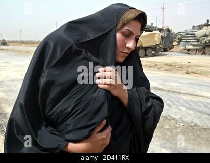 An Iraqi woman, a refugee from the Baghdad area, covers her baby against the heat on the road south-east of Baghdad on April 5, 2003. U.S. tanks which pushed into southern Baghdad on Saturday rumbled back down the main southern highway from the city after linking up with U.S. forces at the airport and carrying out a reconnaissance mission.