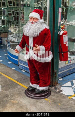 Lima, Peru - December 4, 2008: Closeup of red Santa Claus with large white beard puppet in front of jewelry and fancy gift store. Stock Photo