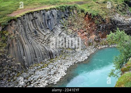 Studlagil Canyon in Northeast Iceland. The blue, green Jokla River passes by the hexagonal basalt columns caused by lava flows.