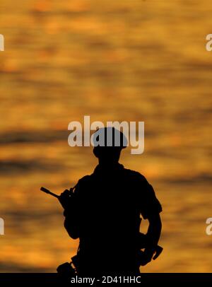 A silhouetted Greek soldier stands guard outside of the awardS ceremony of the Athens 2004 Olympic Games sailing regatta August 25, 2004. REUTERS/Peter Andrews  PA/CRB