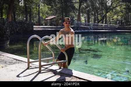 PONCE DE LEON, FLORIDA, UNITED STATES - Oct 18, 2018: A swimmer emerges on a ladder from the water at Ponce De Leon Springs State Park. Stock Photo