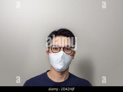 Asian man wearing white face mask close up Stock Photo