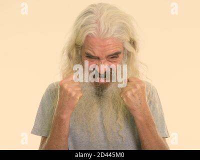 Close up of angry senior bearded man looking furious while raising both arms Stock Photo