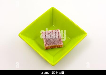 Prickly pear cactus jelly gummy candy square in small green candy bowl on white background Stock Photo