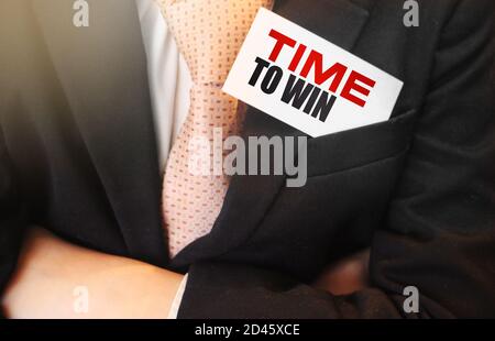 Time to win. Businessman holding a card with a message text written on it. Leadership business concept Stock Photo